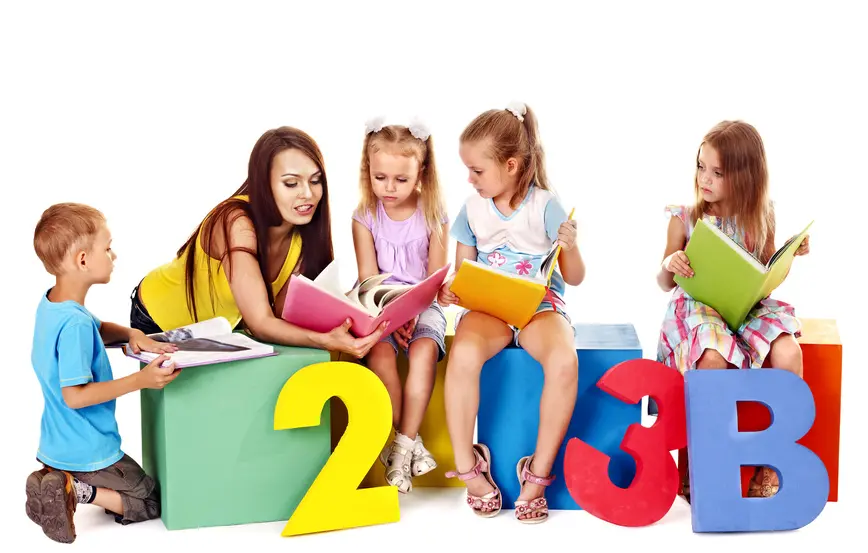 Teacher reading a book to children sitting on blocks with numbers in front